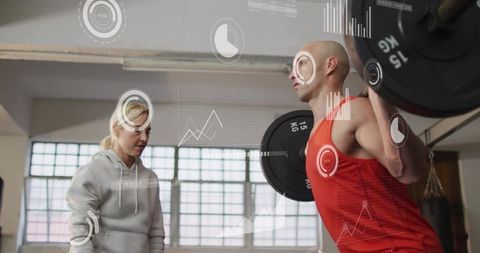 Athlete squatting with barbell and hud fitness analytics while coach observing red top