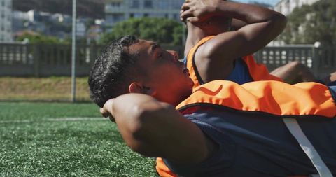 Soccer Players Performing Sit-Ups on Field During Training