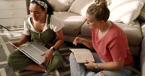 Diverse friends studying together using laptop at home