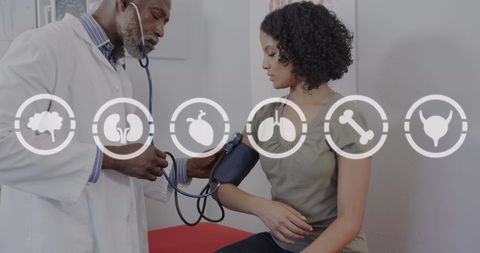 Doctor Measuring Patient's Blood Pressure with Healthcare Icons