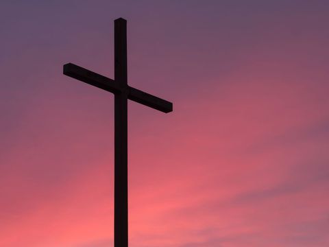 Silhouette of Cross Against Vibrant Sunset Sky