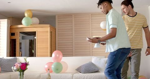 Man Celebrating at Home with Colorful Balloons and Decorations
