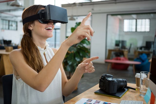 Female graphic designer using the virtual reality headset in creative office