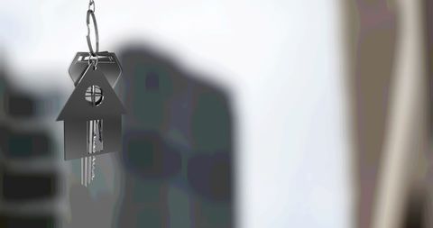 Silver House Key Fob Against Blurred City Skyline