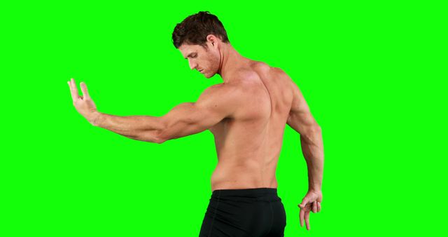 Muscular man seen from the back flexing arm on a green screen background. Ideal for fitness and bodybuilding content, promotional materials for gyms or personal training services, or advertisements for health and wellness products.