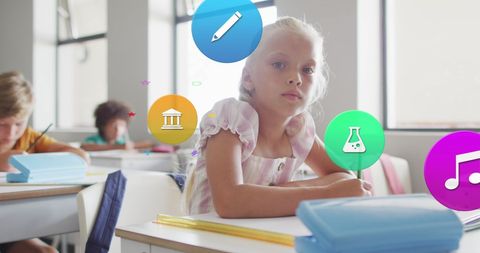Engaged schoolgirl with digital education icons in classroom