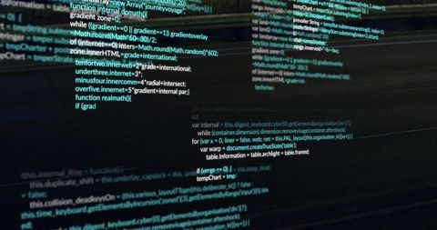 Widescreen code columns scrolling on reflective monitor in dark programming workspace