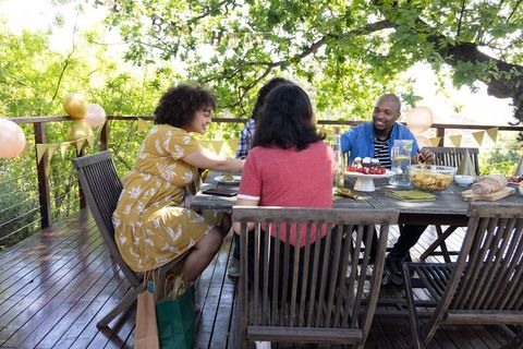 Diverse Friends Sharing Meal at Outdoor Deck Party
