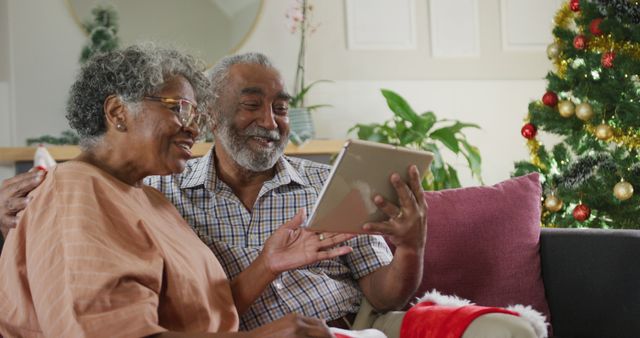 Happy african american senior couple having image call at christmas time. christmas, festivity and communication technology.