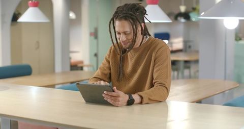 African American Man Using Tablet in Modern Coworking Space Working Remotely