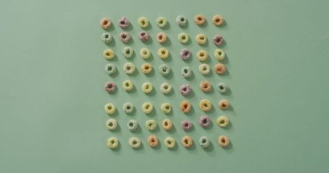 Colorful ring cereals arranged on soft blue background