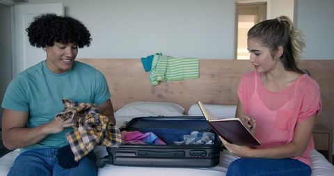 Couple Packing Suitcase for Vacation Adventure in Modern Bedroom
