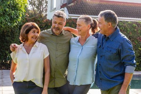 Group of senior friends smiling in backyard gathering