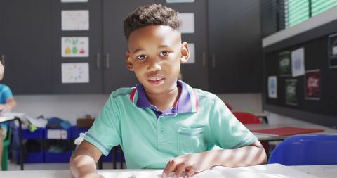 Smiling Schoolboy Sitting at Classroom Desk Ready to Learn - Download Free Stock Images Pikwizard.com