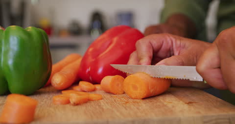 Close-Up of Hands Chopping Fresh Vegetables on Cutting Board