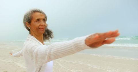 Senior African American Woman Practicing Yoga on Beach