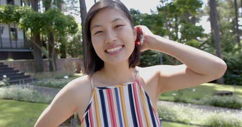 Smiling Asian Woman Enjoying Summertime in Garden