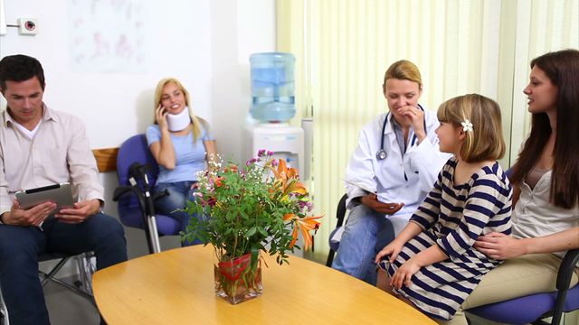 Female doctor discussing with a child's family in a hospital waiting room, indicating personalized care and attention in a medical environment. Modern healthcare scene showcasing professional interaction and technology usage. Useful for healthcare studies, patient involvement, and hospital promotions.