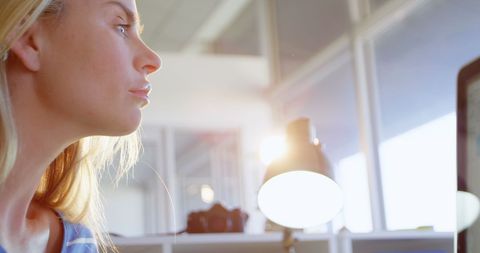 Focused fashion designer working on digital tablet in sunlit office