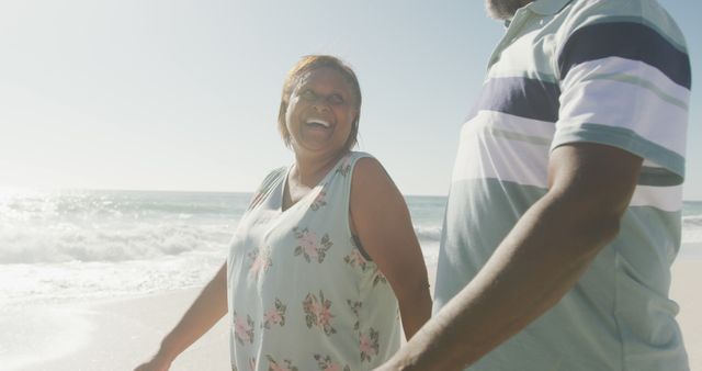 Happy senior couple walking on beach enjoying sunny day - Download Free Stock Images Pikwizard.com