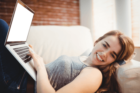 Smiling woman relaxing with laptop having transparent screen