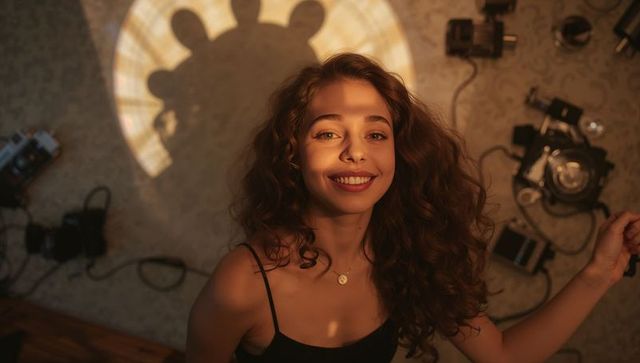 Joyful curly-haired woman in vintage studio lighting