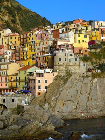 Colorful cliffside village stacked houses overlooking rocky mediterranean sea in cinque terre