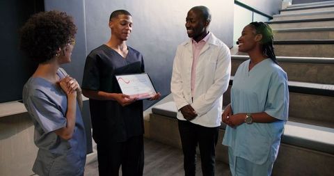 Smiling medical team applauding doctor's achievement award