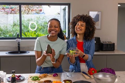African American Friends Preparing Fresh Veggie Meal in Bright Modern Home Kitchen