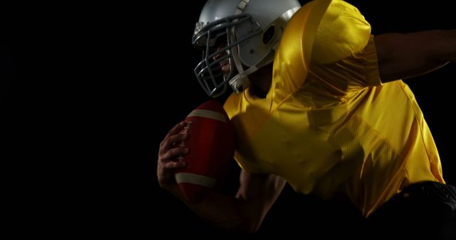 American Football Player Holding Ball Running in Dark Studio - Download Free Stock Images Pikwizard.com