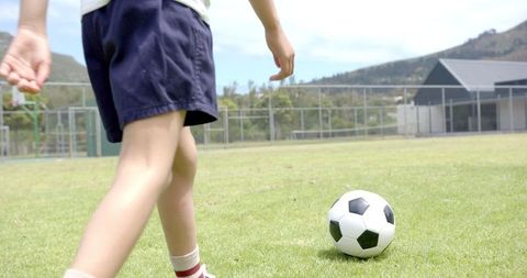 Young Boy Practicing Soccer Ready to Kick Ball on Grass Field