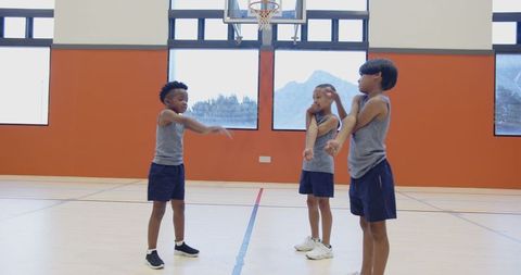 Boys Engaging in Warm-Up Exercises on Indoor Basketball Court
