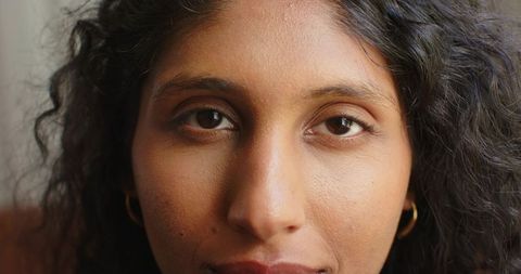 African american woman gazing close-up with curly hair and gold hoop earrings