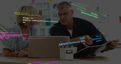 Business-casual team collaborating on software code review with laptop and binder