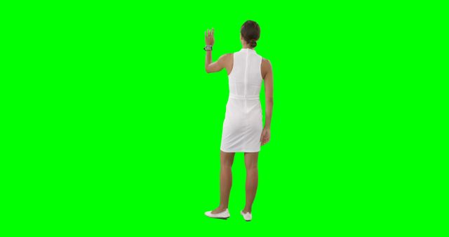 Woman in white dress using virtual interface on green screen - Download Free Stock Images Pikwizard.com