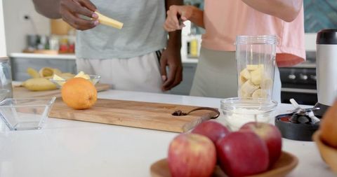 Diverse Couple Making Smoothies in Modern Home Kitchen