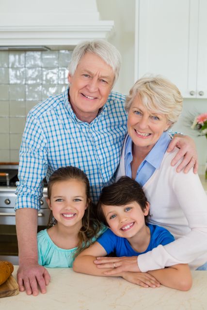 Grandparents and grandchildren smiling and standing together in a bright kitchen. Perfect for use in family-oriented advertisements, lifestyle blogs, and articles about family bonding and multigenerational households.