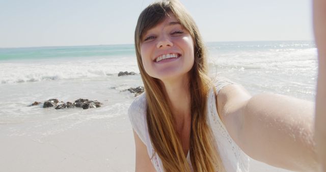 Portrait of happy caucasian woman with long brown hair at sunny beach. Vacation, summer and lifestyle, unaltered.