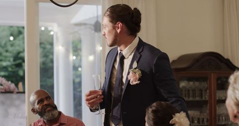 Groom giving toast in elegant wedding reception celebration