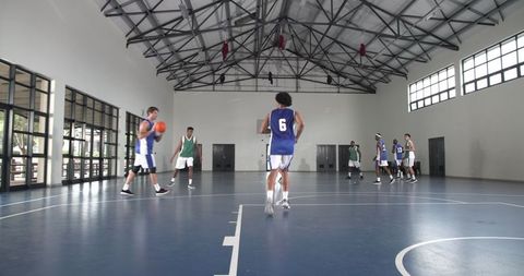 Diverse Male Basketball Players Engaged in an Intense Game in Indoor Court
