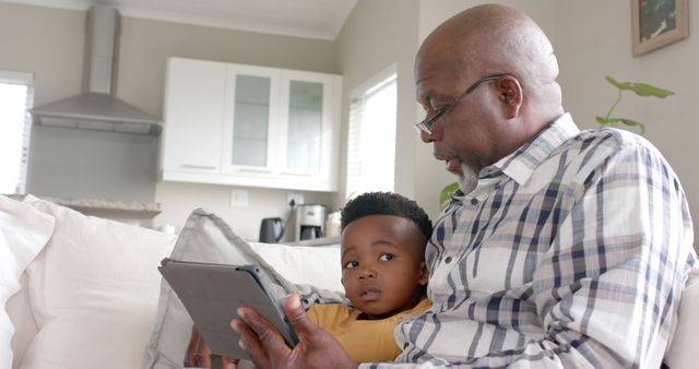 Grandfather and grandson using tablet on sofa - Download Free Stock Images Pikwizard.com