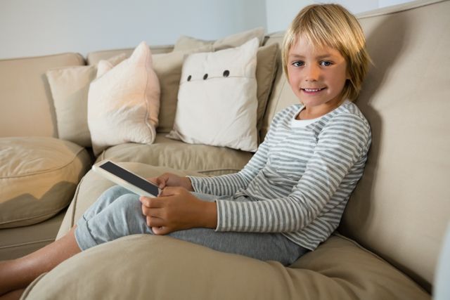 Portrait of boy using digital tablet in the living room at home
