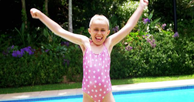 Happy girl jumping near swimming pool