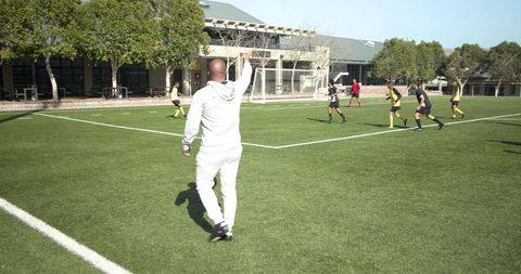 Soccer coach guiding team during outdoor practice session