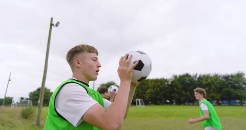 Teenage boys practicing soccer together outdoors