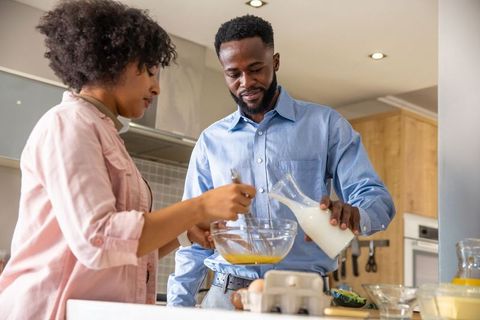 Couple Collaborating in Modern Kitchen Cooking Meal Together
