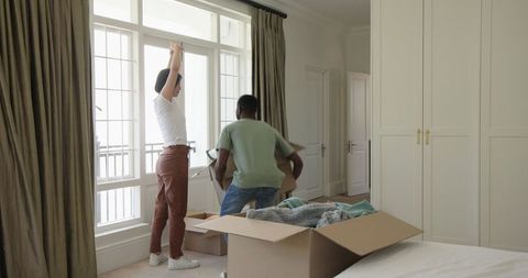 Happy Couple Unpacking Boxes in Bright New Home