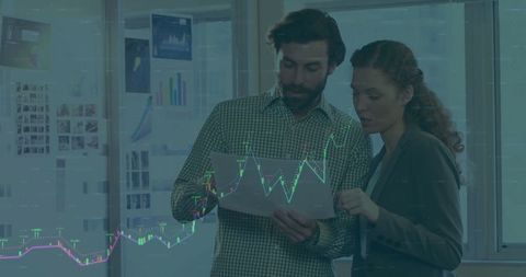 Business professionals analyzing financial charts in office