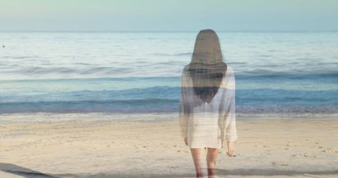 Serene Woman Walking on Sandy Beach with Gentle Waves
