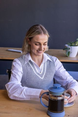 Professional Woman Enjoying Freshly Brewed French Press Coffee at Office Workspace